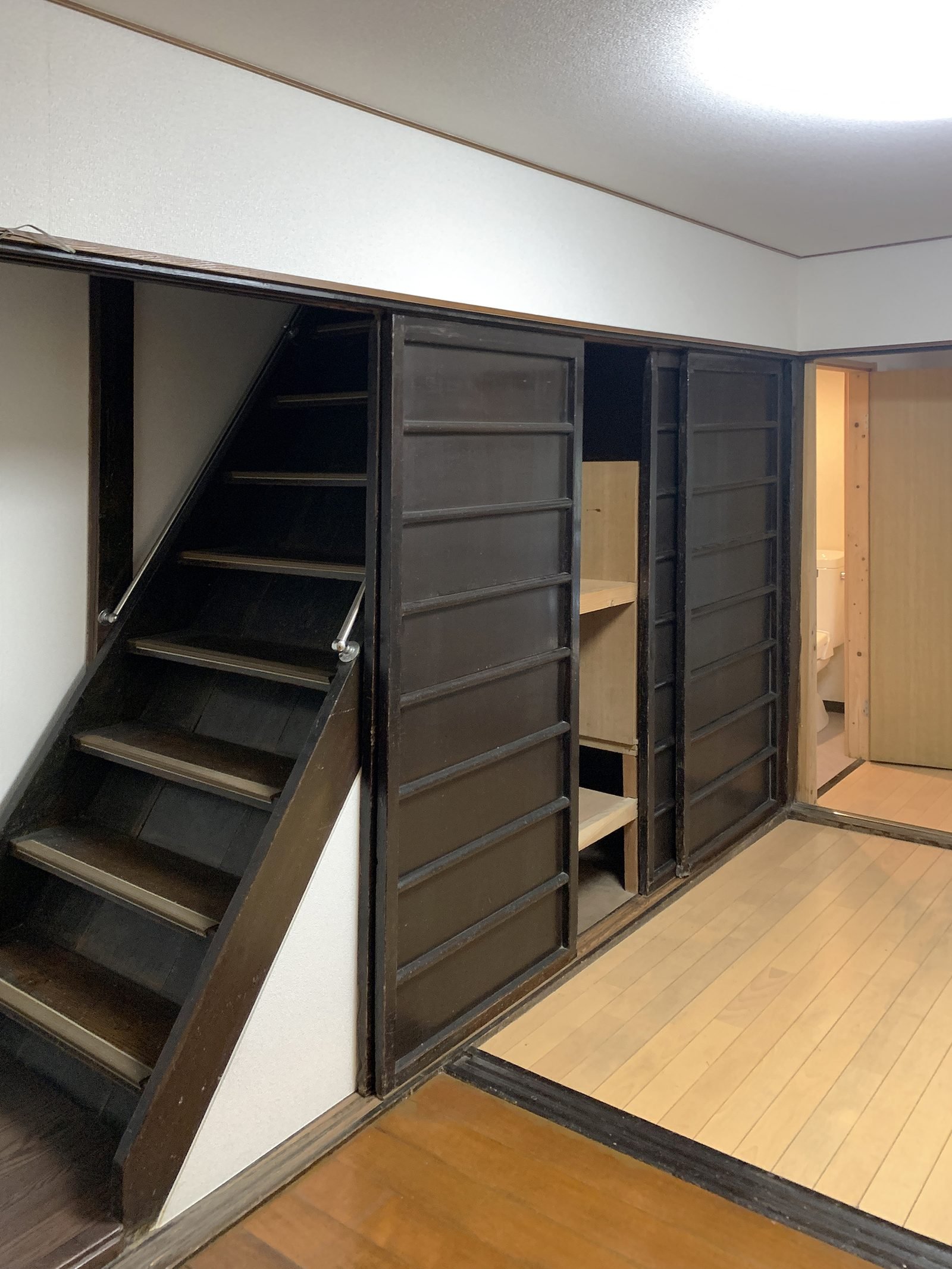 Original steep staircase with dark wood storage